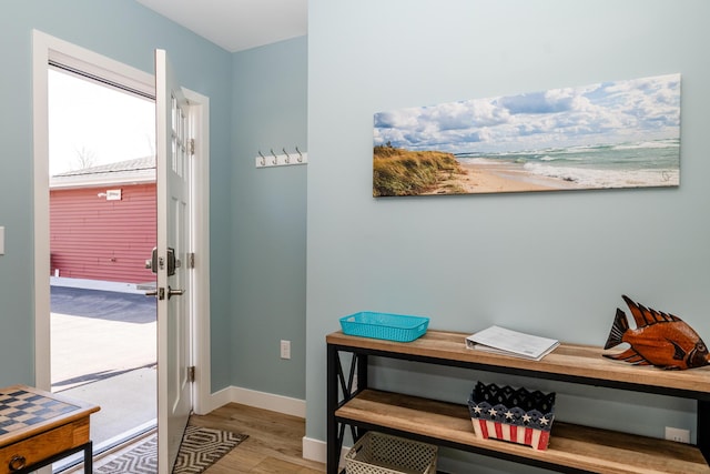 doorway featuring wood finished floors and baseboards