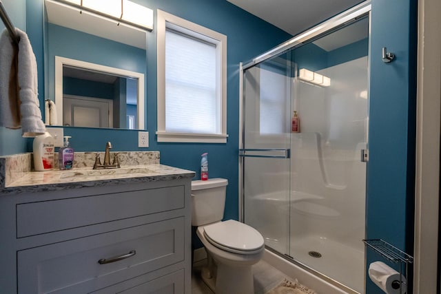 bathroom with a stall shower, toilet, and vanity