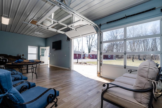 interior space with baseboards, a garage, and wood finished floors