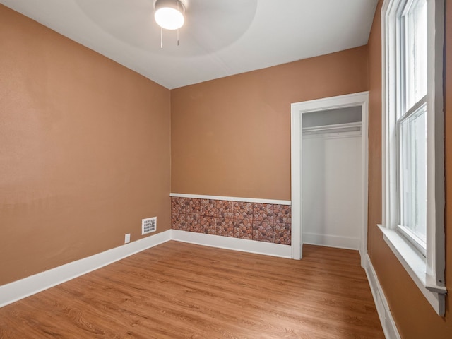 unfurnished bedroom with light wood-style flooring, baseboards, and visible vents