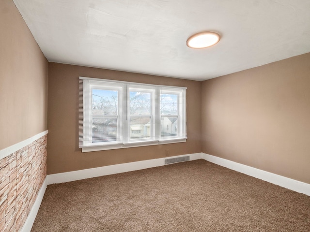 spare room with visible vents, carpet floors, and baseboards