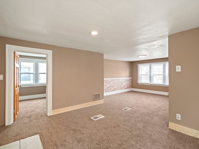 carpeted spare room with baseboards and visible vents