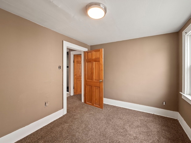 unfurnished room with baseboards and carpet floors