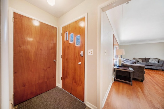 foyer entrance featuring baseboards and wood finished floors