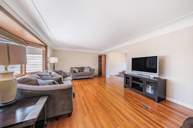 living area with light wood-style flooring and baseboards