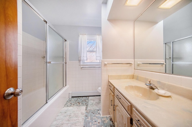 bathroom with tile patterned flooring, toilet, vanity, tile walls, and a baseboard radiator