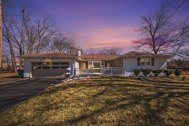 ranch-style house with driveway, covered porch, a front yard, an attached garage, and a chimney