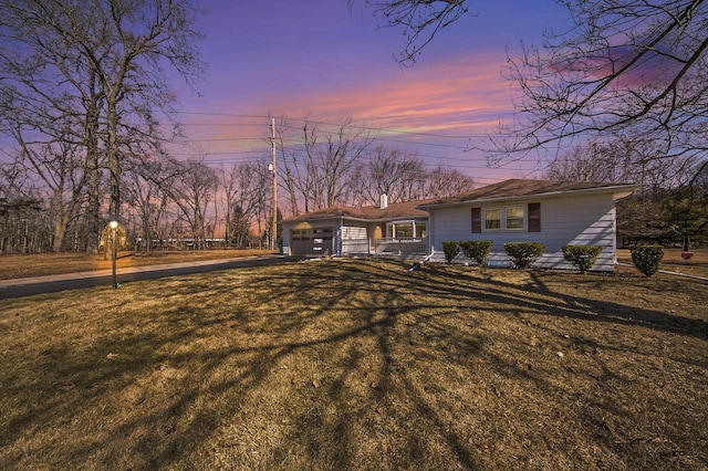 view of front of home with driveway, a front lawn, and a garage