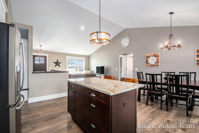 kitchen featuring dark wood-type flooring, freestanding refrigerator, dark brown cabinetry, lofted ceiling, and a chandelier