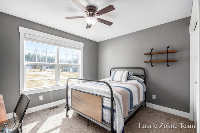 carpeted bedroom with visible vents, baseboards, and a ceiling fan