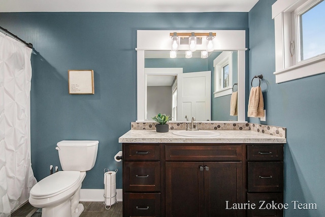 full bath featuring baseboards, toilet, and vanity