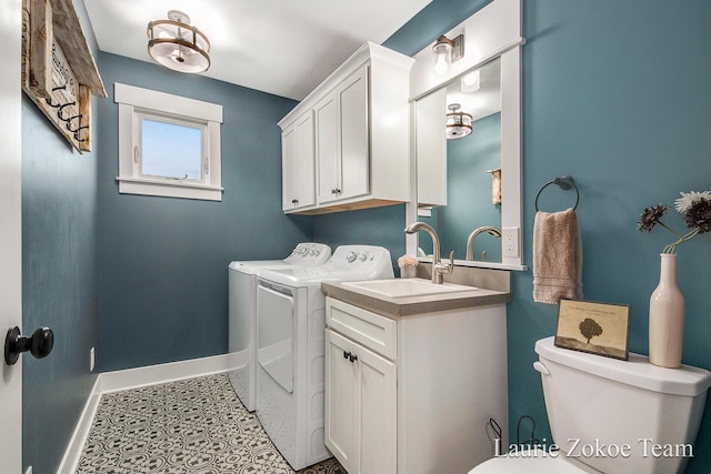 washroom featuring tile patterned floors, a sink, separate washer and dryer, baseboards, and laundry area