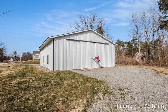 view of pole building featuring gravel driveway and a yard