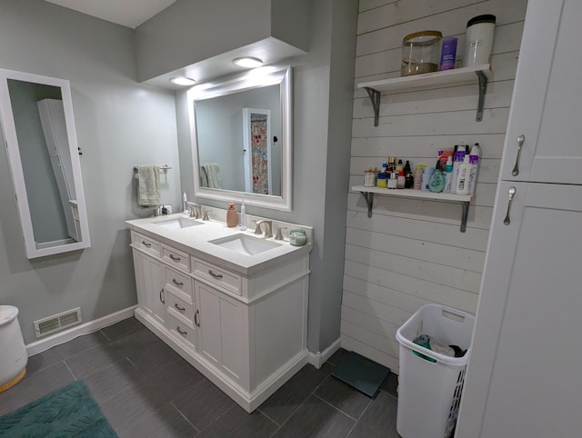 674 Booth Rd, Bronson, MI 49028 - bathroom featuring wood walls, double vanity, visible vents, and a sink