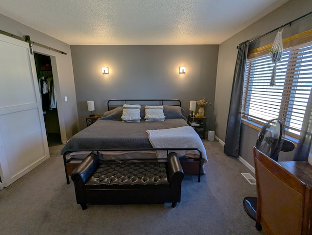 674 Booth Rd, Bronson, MI 49028 - bedroom featuring a barn door, visible vents, a textured ceiling, and carpet floors