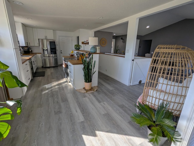 674 Booth Rd, Bronson, MI 49028 - kitchen with white cabinets, stainless steel refrigerator with ice dispenser, wooden counters, wood finished floors, and a kitchen island