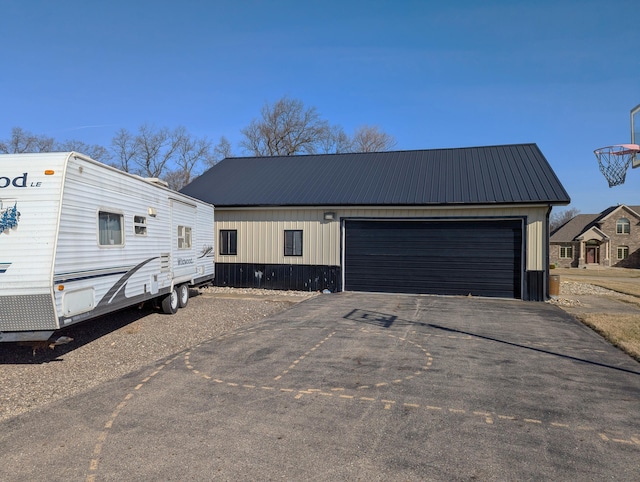 674 Booth Rd, Bronson, MI 49028 - view of front of property with an outdoor structure, metal roof, a garage, and aphalt driveway
