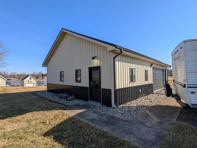 674 Booth Rd, Bronson, MI 49028 - view of property exterior featuring a yard, board and batten siding, and a garage