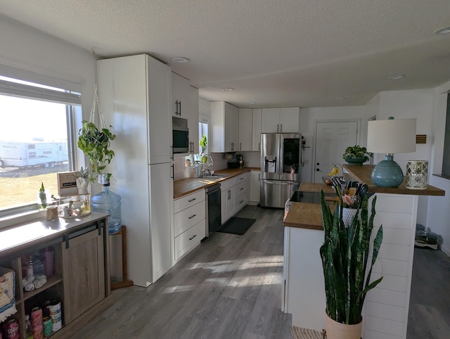 674 Booth Rd, Bronson, MI 49028 - kitchen with a healthy amount of sunlight, butcher block countertops, light wood-style floors, and appliances with stainless steel finishes
