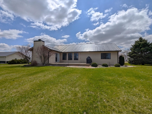 674 Booth Rd, Bronson, MI 49028 - rear view of house featuring metal roof, a chimney, and a lawn