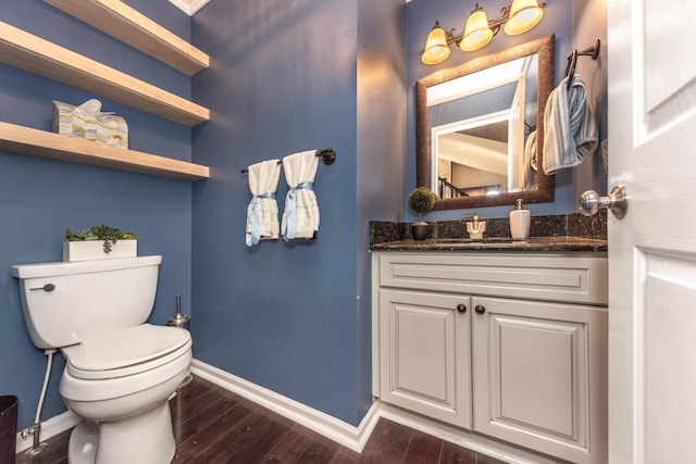 bathroom featuring vanity, toilet, wood finished floors, and baseboards