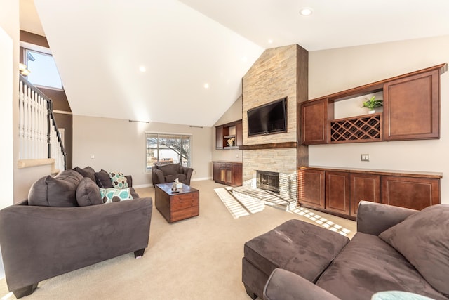 living area with light carpet, high vaulted ceiling, stairway, a stone fireplace, and baseboards