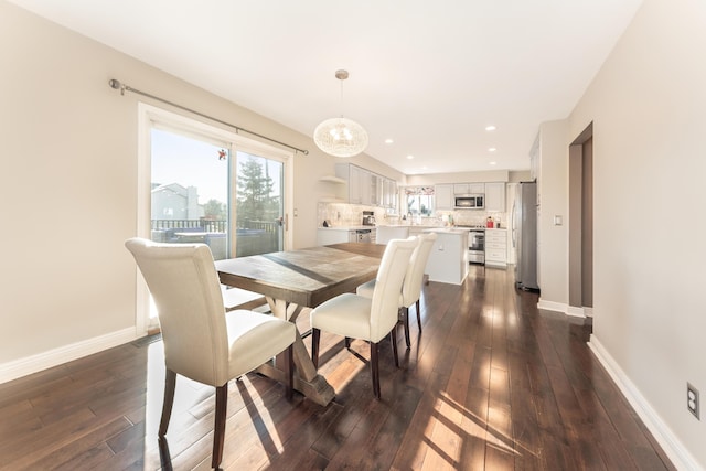 dining area with an inviting chandelier, dark wood-type flooring, recessed lighting, and baseboards