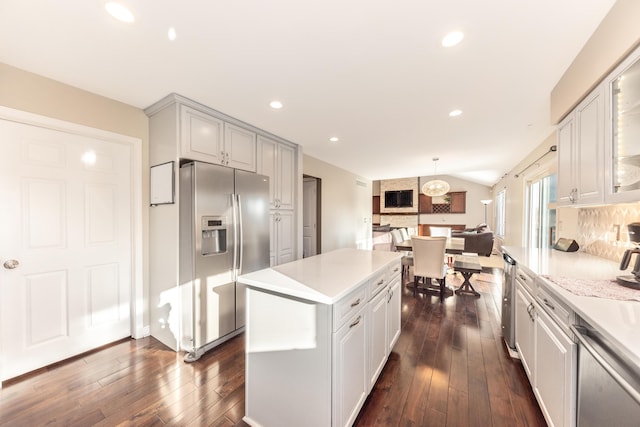 kitchen featuring stainless steel appliances, dark wood finished floors, vaulted ceiling, and light countertops