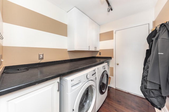 washroom featuring rail lighting, cabinet space, dark wood-style flooring, and washing machine and clothes dryer