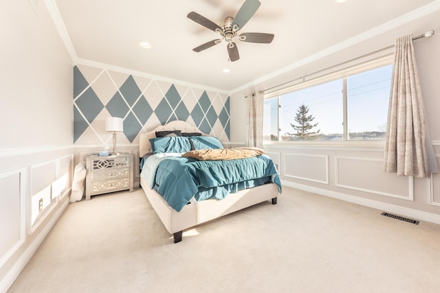 carpeted bedroom with visible vents, wallpapered walls, ornamental molding, an accent wall, and a decorative wall