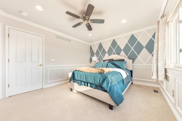 bedroom featuring an accent wall, crown molding, light colored carpet, and visible vents