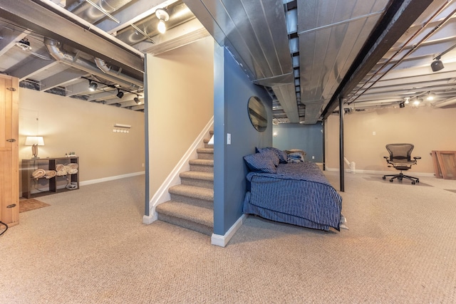 finished below grade area featuring stairway, carpet floors, and baseboards