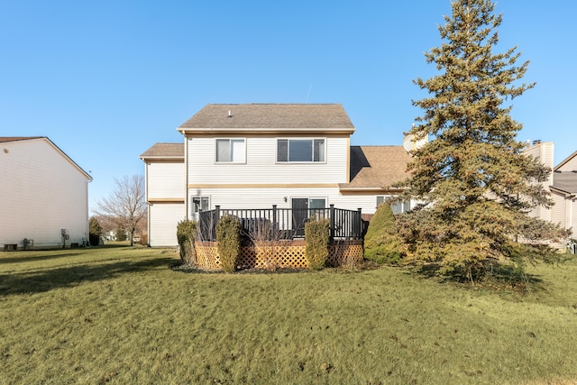back of property featuring a lawn, a deck, and roof with shingles