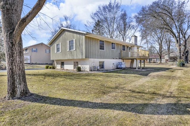 view of front of home with brick siding, a front lawn, board and batten siding, and a chimney