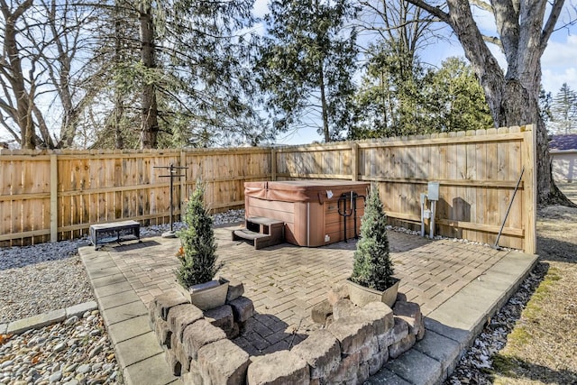 view of patio featuring a hot tub and a fenced backyard