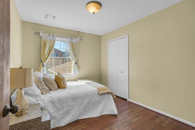 bedroom featuring a closet, baseboards, and wood finished floors