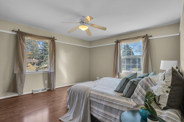 bedroom featuring visible vents, baseboards, wood finished floors, and a ceiling fan