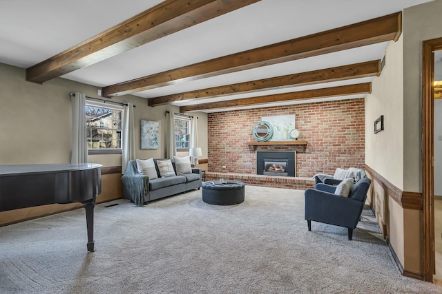 carpeted living area featuring a brick fireplace and beamed ceiling