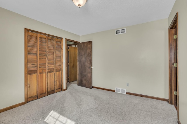 carpeted bedroom with a closet, visible vents, and baseboards