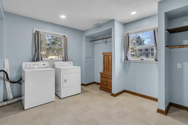 washroom with washing machine and clothes dryer, visible vents, baseboards, laundry area, and recessed lighting