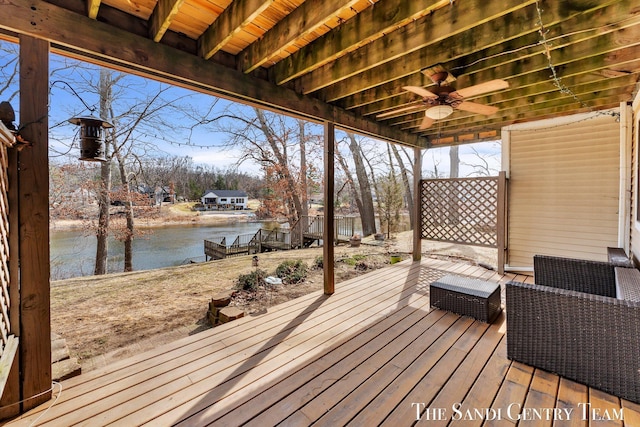 wooden deck with a water view and a ceiling fan