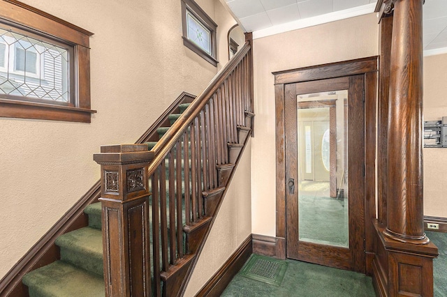 stairs featuring visible vents, baseboards, carpet, and a textured wall