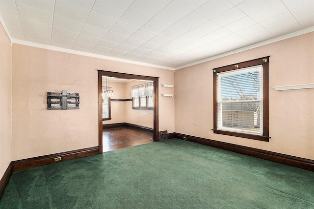 spare room with dark carpet, baseboards, and ornamental molding