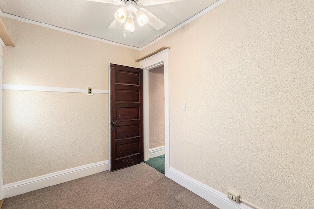 empty room featuring a ceiling fan, crown molding, carpet, and baseboards