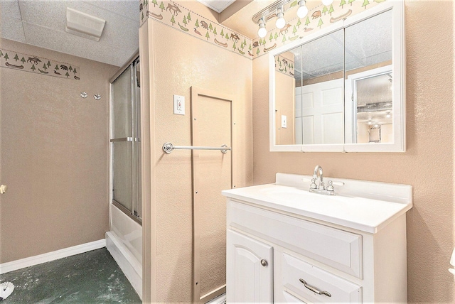 full bathroom featuring vanity, baseboards, and bath / shower combo with glass door