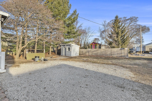 view of yard featuring an outbuilding, a storage unit, and fence