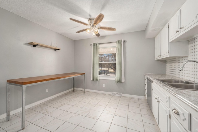 kitchen with a ceiling fan, a sink, decorative backsplash, light countertops, and white cabinetry