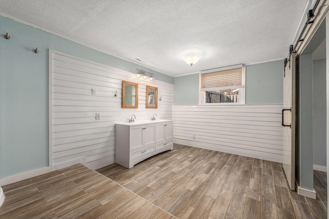 bathroom with vanity, wood finished floors, visible vents, and a textured ceiling