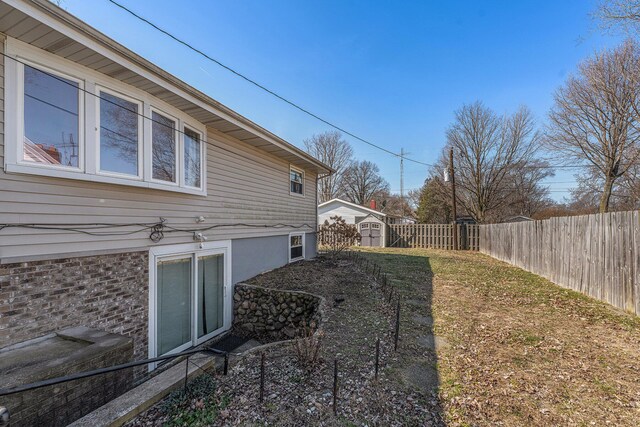 view of yard featuring an outdoor structure, a storage unit, and a fenced backyard