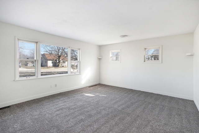 empty room with visible vents, baseboards, and carpet flooring